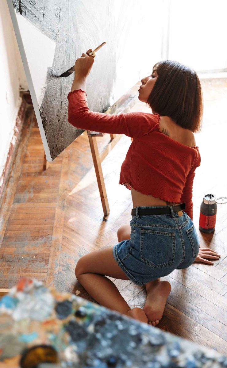 portrait-of-young-woman-using-painting-tools-while-92SJDEG.jpg